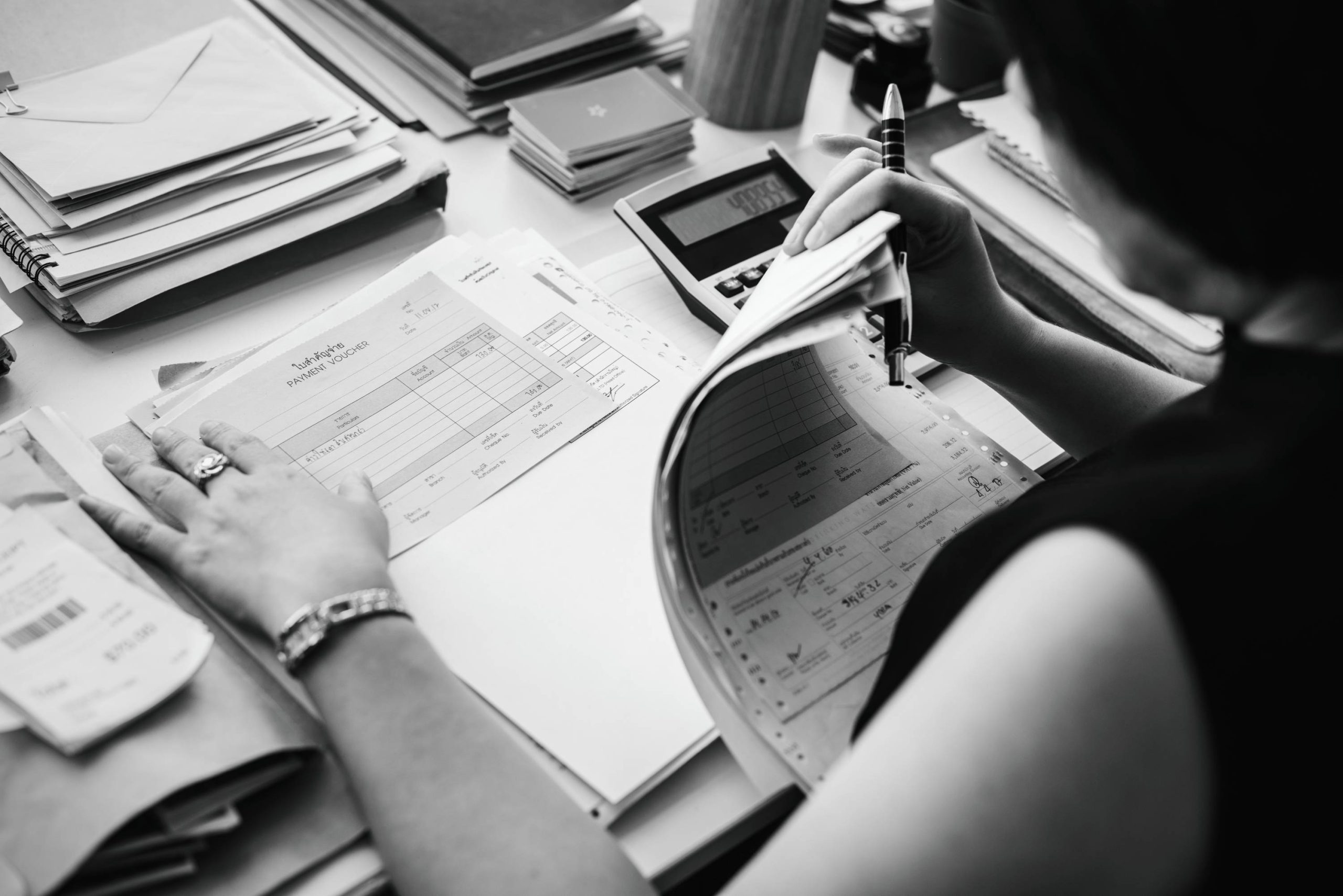 asian woman working through paperwork 1 scaled