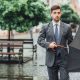 attractive man goes down street with umbrella looks front 1 80x80